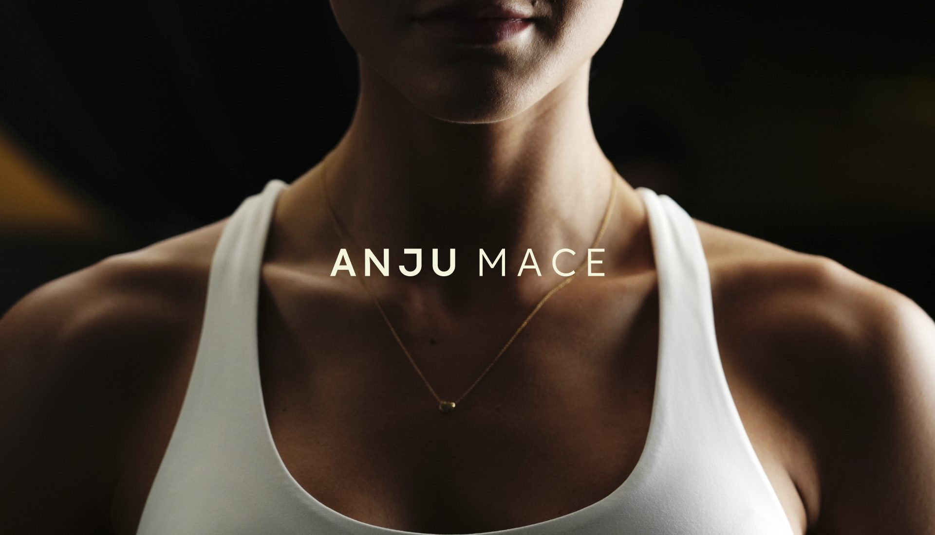 Assinatura ANJU MACE sobre retrato de mulher de regata branca em luz baixa