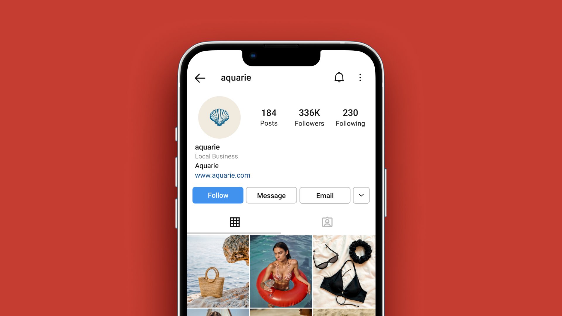 Celular sobre fundo vermelho coral mostrando o perfil da Aquarie no Instagram, com a concha como foto de perfil e posts de moda praia